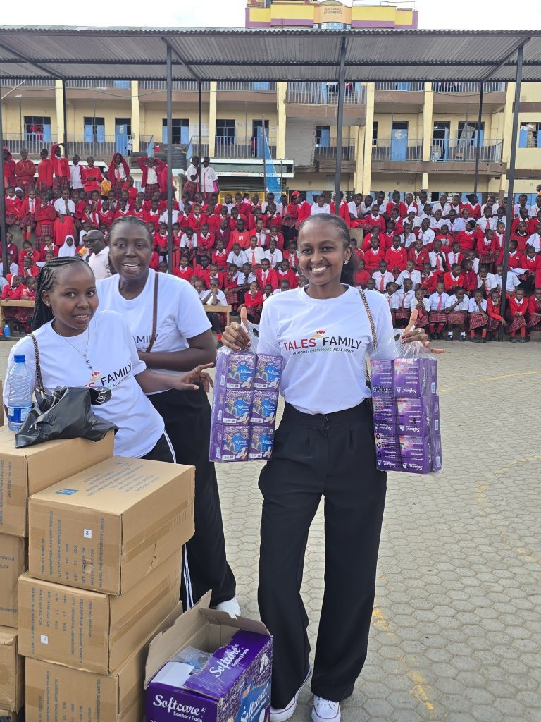 The Tales Family team with boxes of sanitary pads at a school
